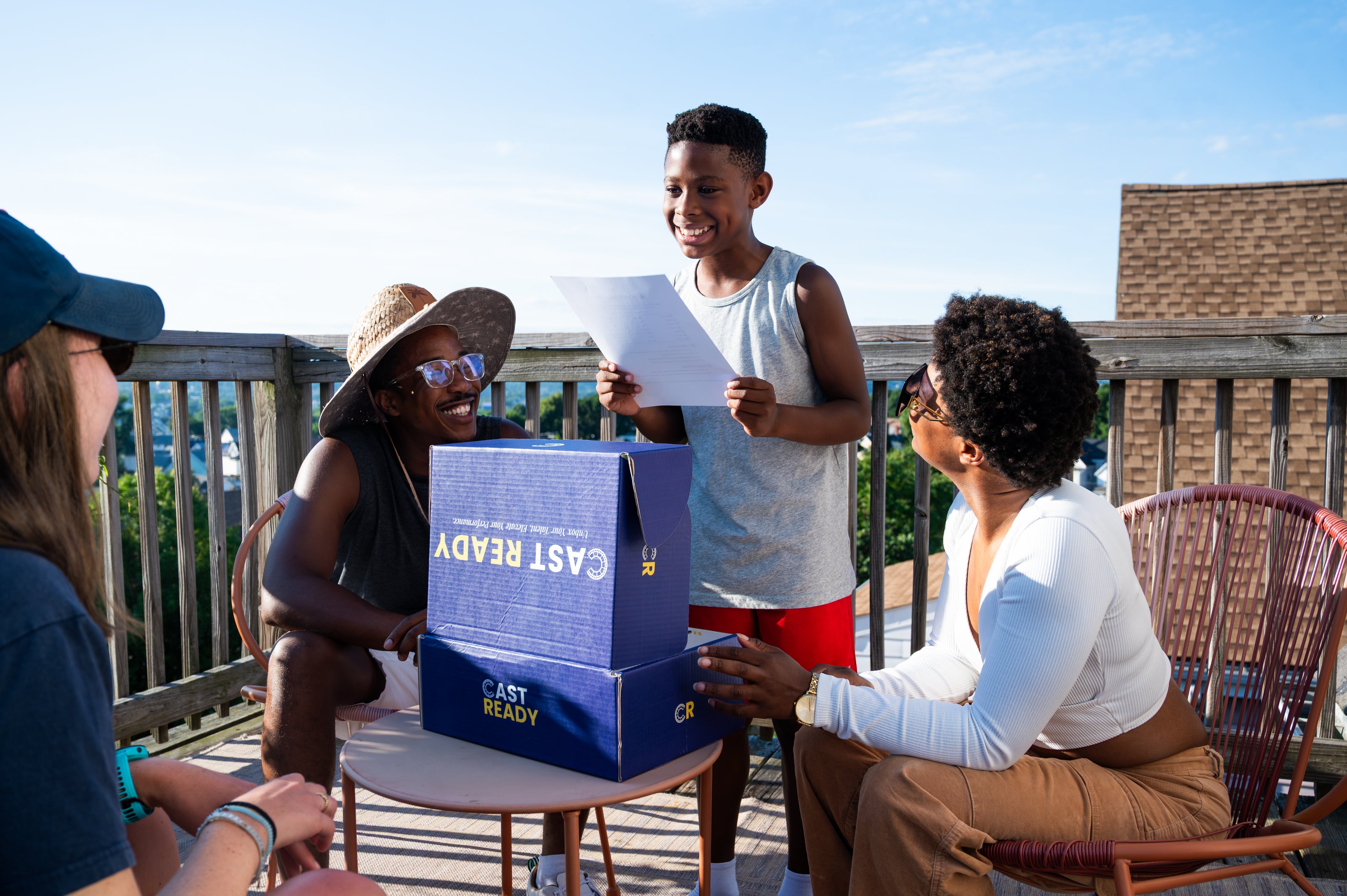Smiling family and friends gathered outdoors, supporting a young actor practicing with a CastReady kit, representing inclusive and supportive acting education community